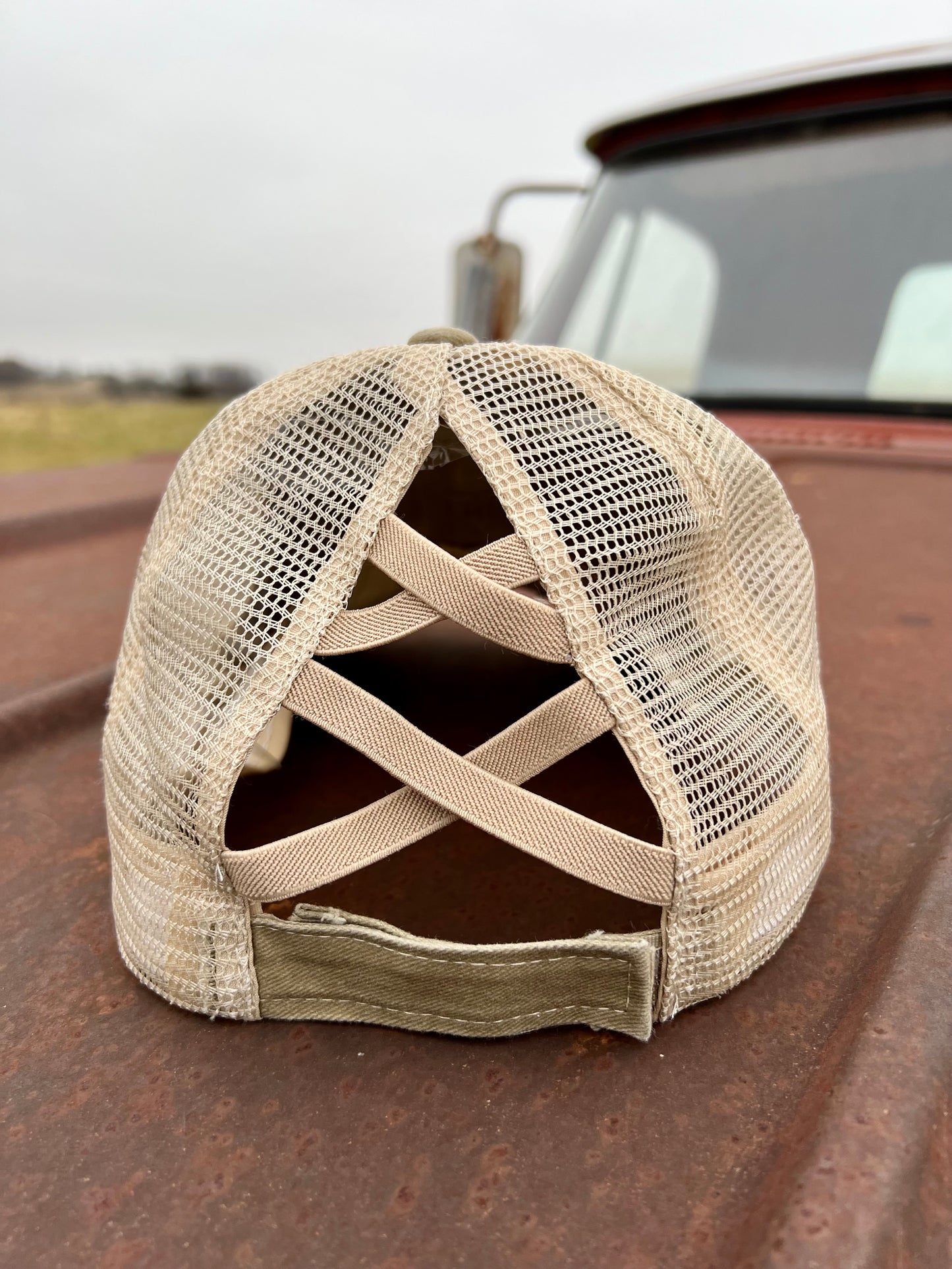 Back of Khaki baseball cap with stretchy criss cross bands and adjustable velcro strap