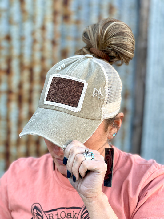Khaki distressed baseball cap with leather and material raggy patch.