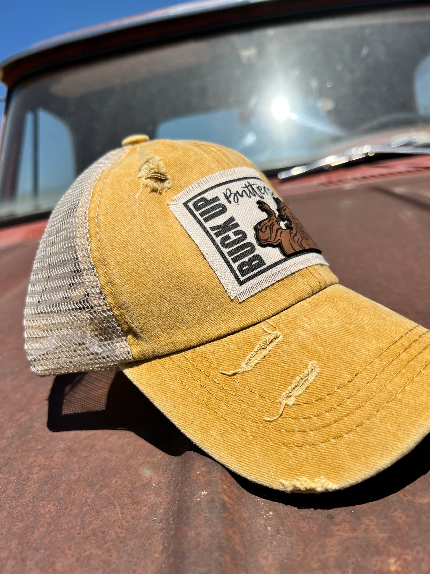 Side view of distressed mustard cap with patch 