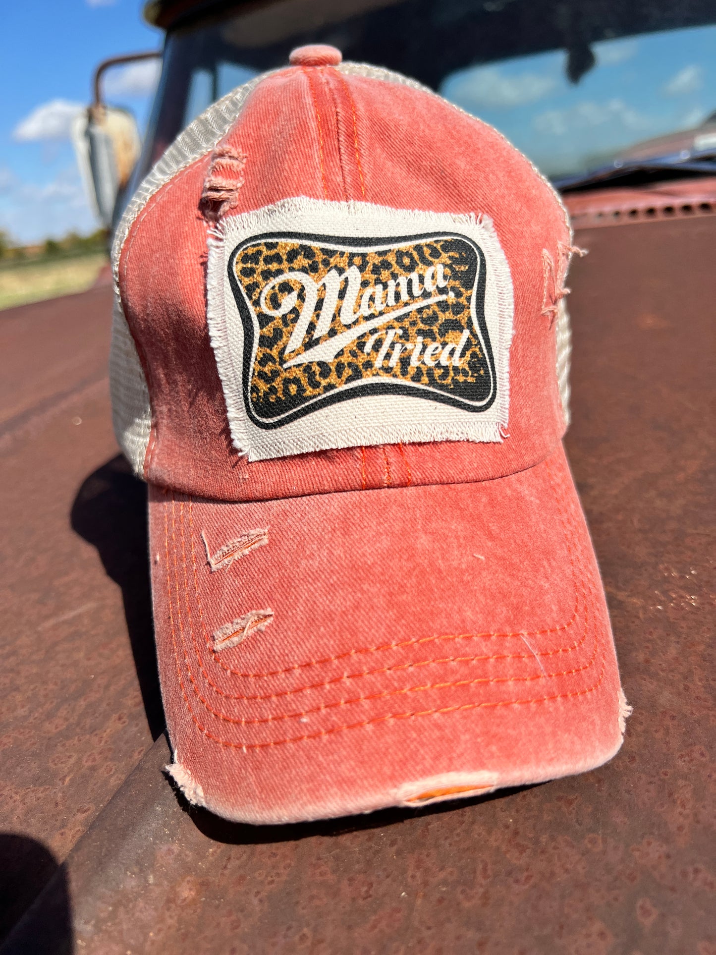 Orange distressed baseball cap with material raggy patch with saying "Mama Tried" 