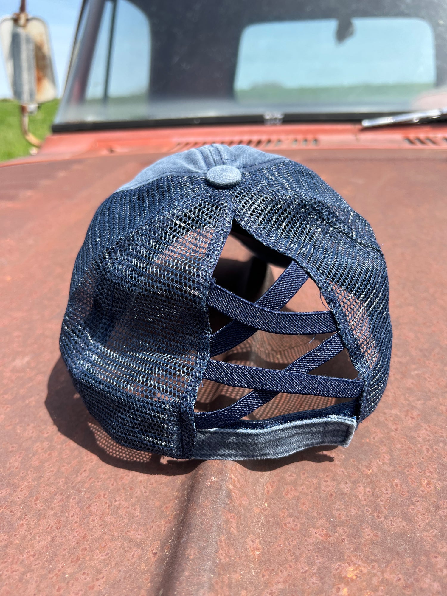 Back of Navy Distressed Baseball Cap with stretch criss cross ponytail back and adjustable velcro strap. 